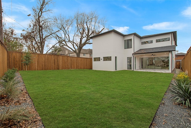 back of house featuring a yard and ceiling fan