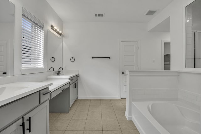 bathroom featuring tile patterned flooring, vanity, and a tub