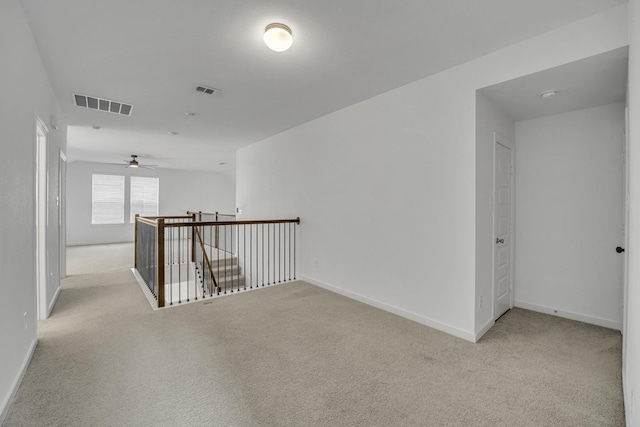 carpeted spare room featuring ceiling fan