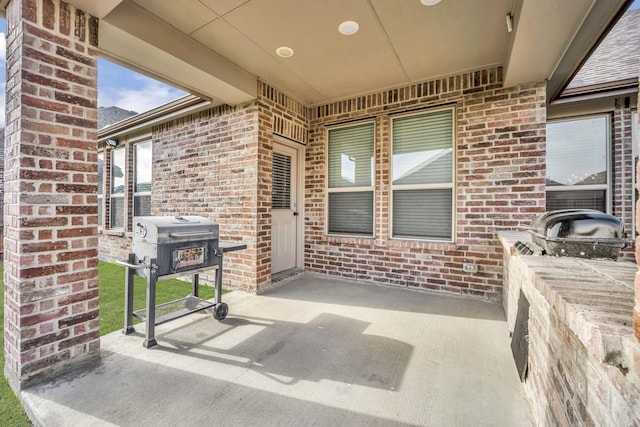 view of exterior entry with a patio area