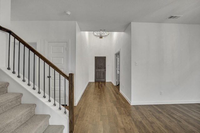 entryway with hardwood / wood-style floors and an inviting chandelier