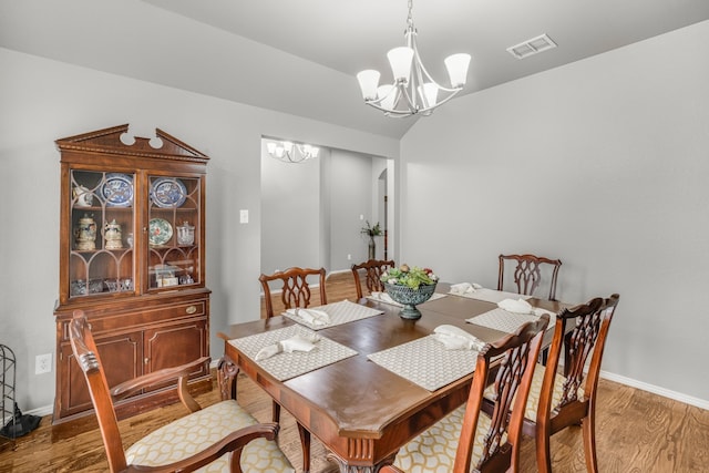 dining room featuring wood-type flooring and a notable chandelier