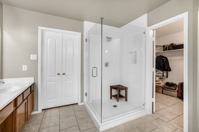 bathroom featuring tile patterned floors, vanity, and a shower with door