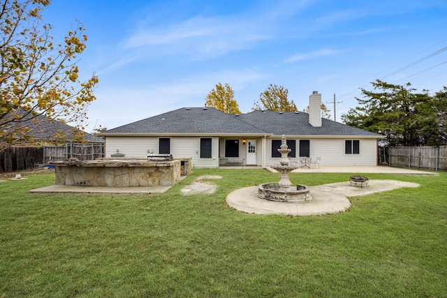 rear view of property with a patio and a lawn