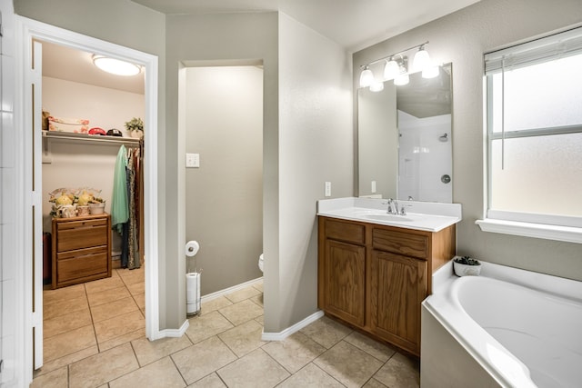 bathroom featuring vanity, a bathtub, plenty of natural light, and tile patterned floors