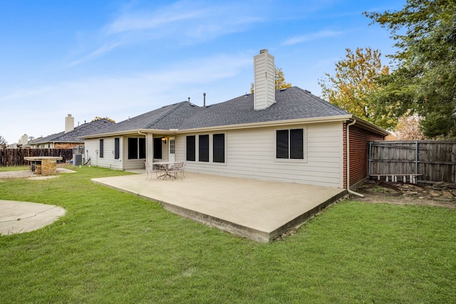 rear view of property featuring a yard, central AC unit, and a patio area