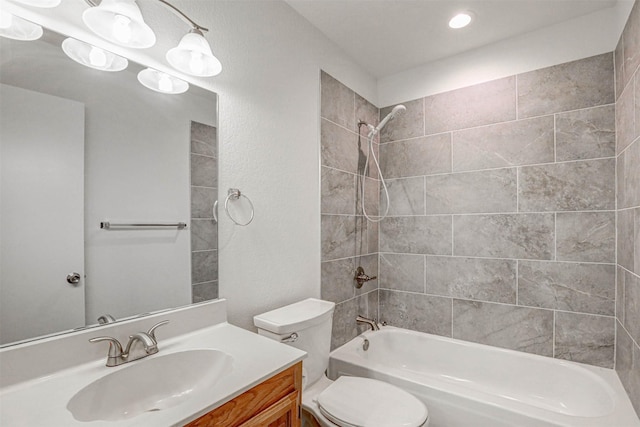 full bathroom featuring toilet, vanity, and tiled shower / bath