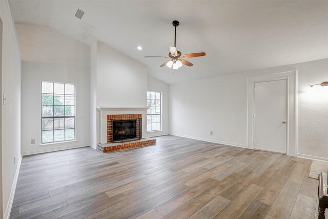 unfurnished living room featuring a fireplace, light wood-type flooring, plenty of natural light, and ceiling fan