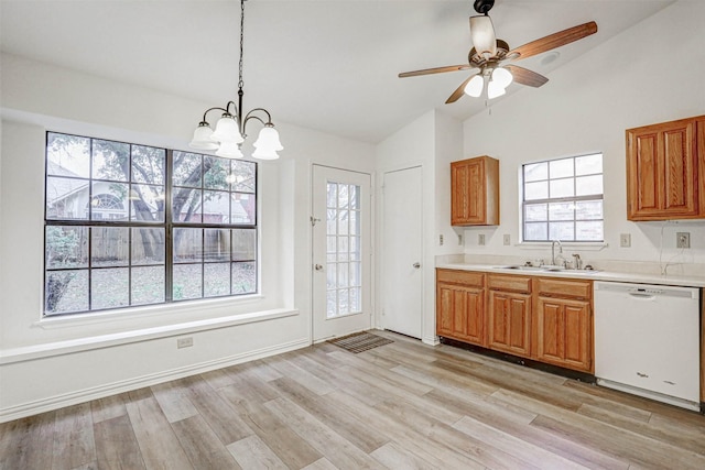 kitchen with a wealth of natural light, vaulted ceiling, sink, pendant lighting, and dishwasher