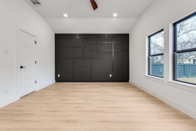 unfurnished bedroom featuring ceiling fan, light wood-type flooring, and vaulted ceiling