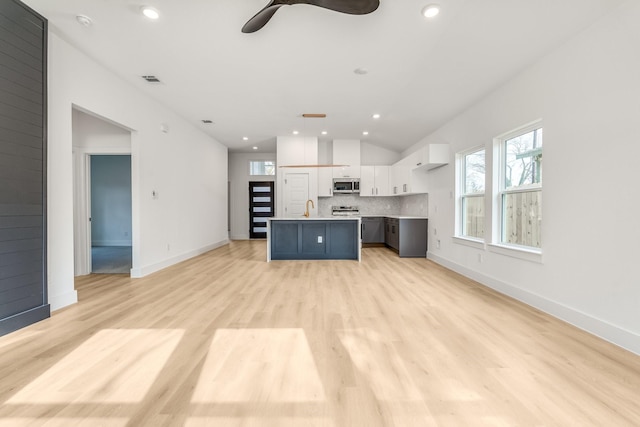 kitchen featuring tasteful backsplash, white cabinetry, a kitchen island, and a wealth of natural light