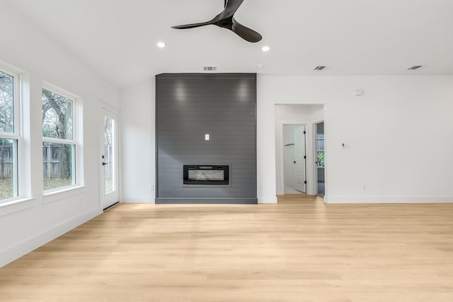 unfurnished living room with ceiling fan, light hardwood / wood-style floors, and a fireplace