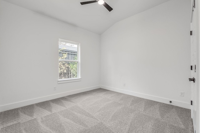 spare room with carpet flooring, vaulted ceiling, and ceiling fan