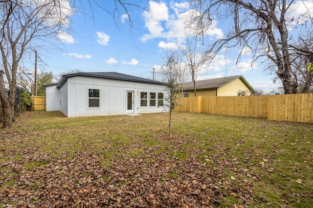 back of house with a lawn