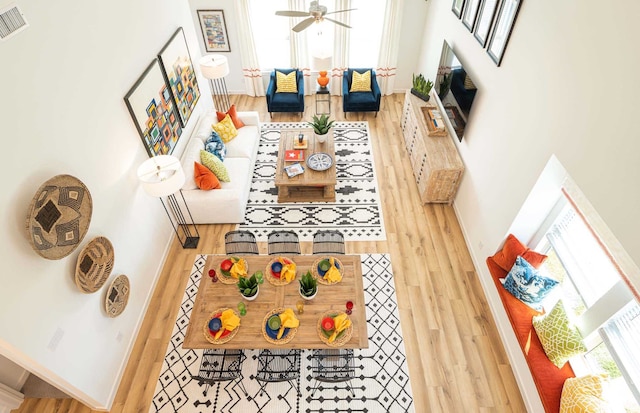 interior space featuring ceiling fan, a high ceiling, and hardwood / wood-style flooring