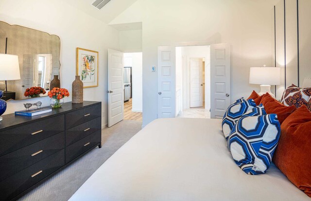 bedroom with light carpet and vaulted ceiling