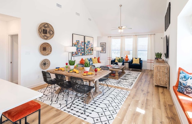 dining area featuring high vaulted ceiling, ceiling fan, and light hardwood / wood-style floors