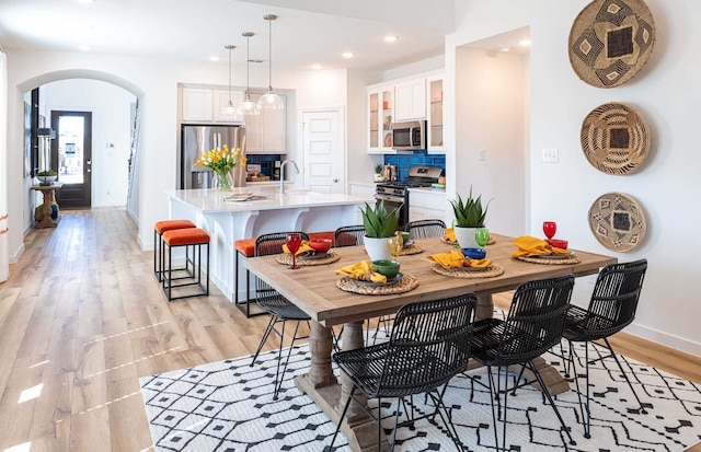 dining space with sink and light hardwood / wood-style flooring