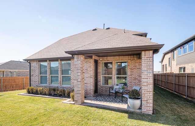 back of house featuring a patio area and a lawn