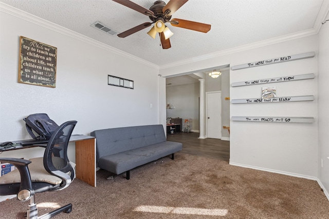 carpeted home office with ceiling fan, ornamental molding, and a textured ceiling