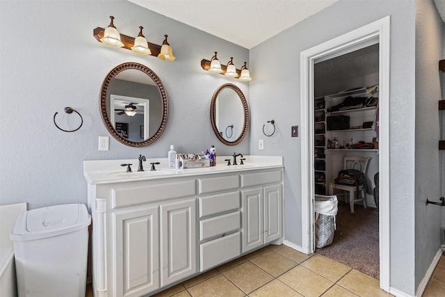 bathroom with a textured ceiling, vanity, tile patterned floors, and ceiling fan