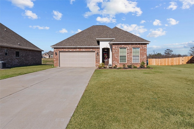 view of front of home with central AC, a garage, and a front yard