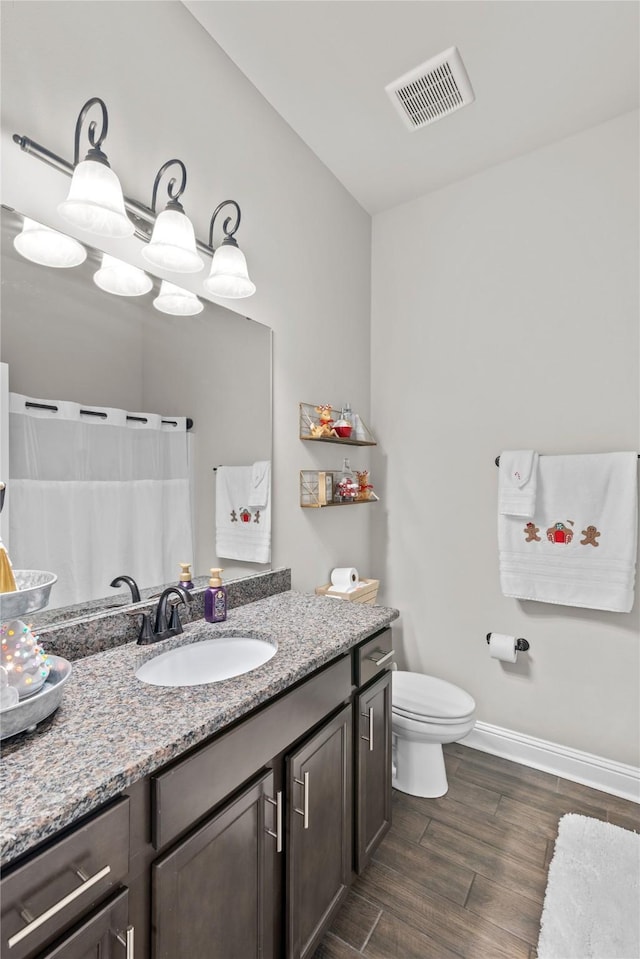 bathroom with vanity, wood-type flooring, and toilet