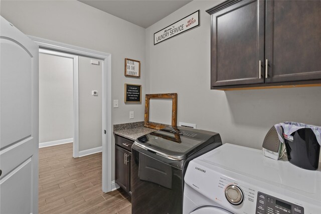 washroom featuring washer and clothes dryer and cabinets