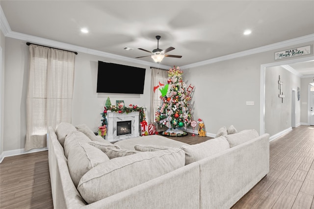 living room with a fireplace, ceiling fan, crown molding, and hardwood / wood-style floors