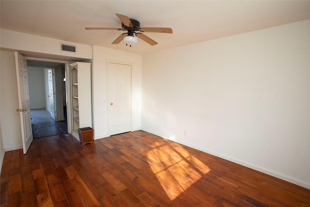 unfurnished bedroom featuring a closet, ceiling fan, and dark hardwood / wood-style flooring