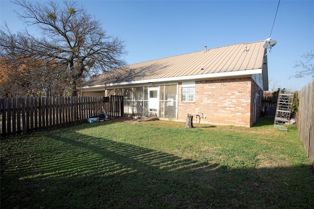 rear view of property with a lawn and a sunroom