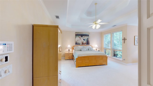 carpeted bedroom with a raised ceiling, ceiling fan, and crown molding