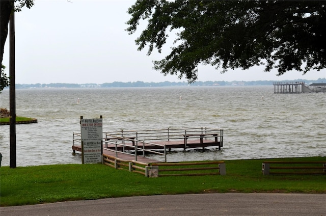 dock area featuring a water view and a lawn