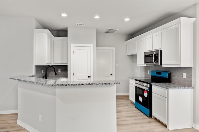 kitchen featuring white cabinetry, light stone countertops, light hardwood / wood-style flooring, black electric range oven, and decorative backsplash