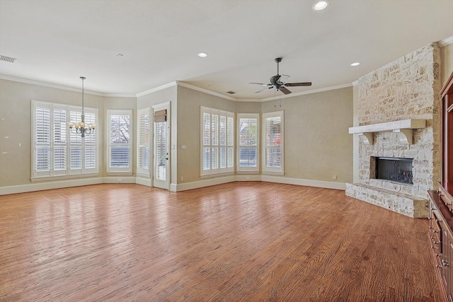 unfurnished living room with hardwood / wood-style floors, ceiling fan with notable chandelier, crown molding, and a fireplace