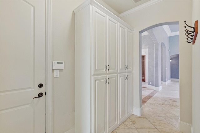 corridor featuring crown molding and light tile patterned flooring