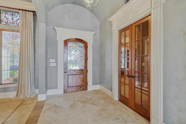 entryway with french doors and a notable chandelier