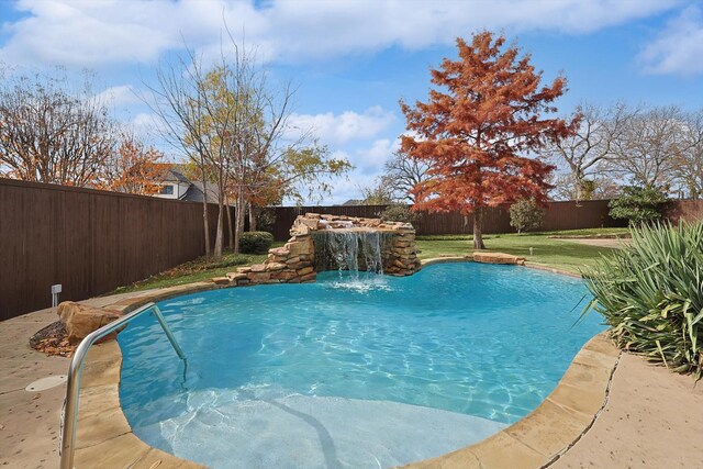 view of swimming pool with a lawn and pool water feature