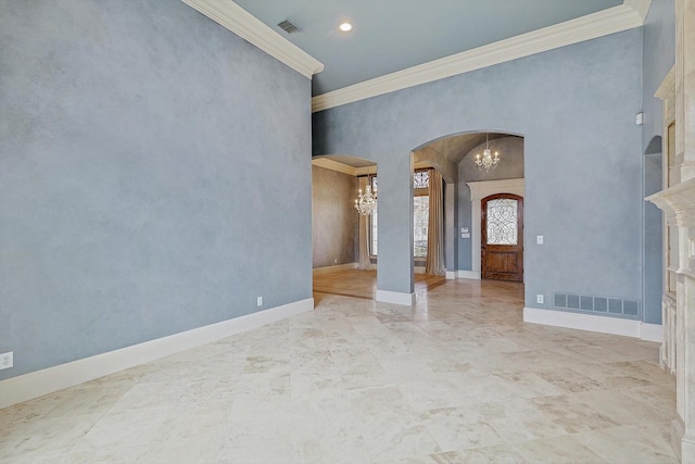 entrance foyer with a fireplace, crown molding, and a notable chandelier