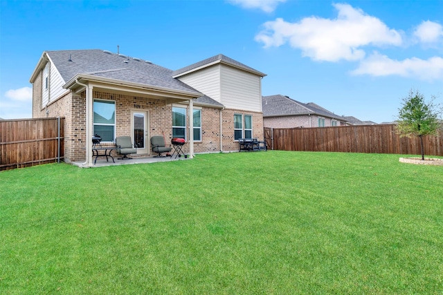 back of house with a patio area and a lawn