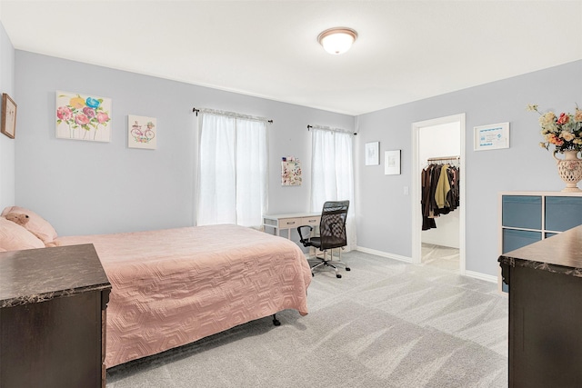 carpeted bedroom with a spacious closet and a closet