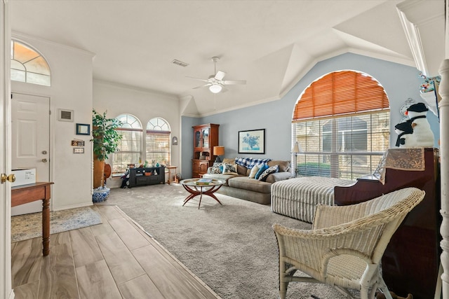 living room featuring ceiling fan, ornamental molding, and vaulted ceiling