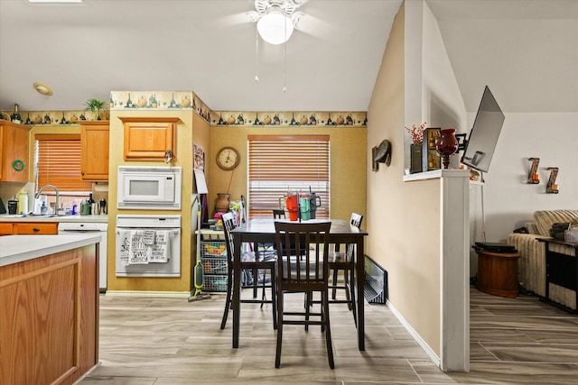 kitchen featuring ceiling fan, sink, and white appliances