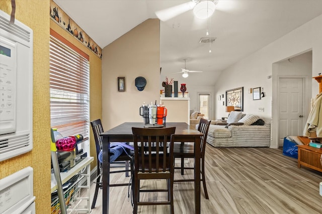 dining space featuring hardwood / wood-style flooring, vaulted ceiling, and ceiling fan