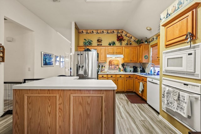 kitchen featuring sink, white appliances, light hardwood / wood-style flooring, and a kitchen island