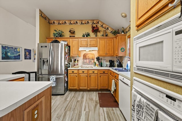 kitchen featuring lofted ceiling, sink, and white appliances