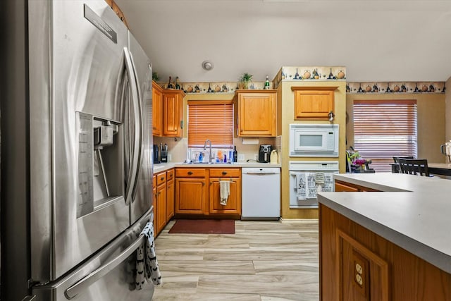 kitchen featuring sink, white appliances, and light hardwood / wood-style flooring