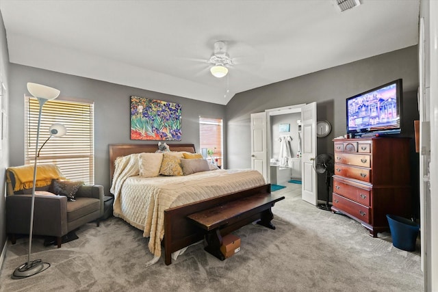 bedroom with ceiling fan, connected bathroom, and light colored carpet