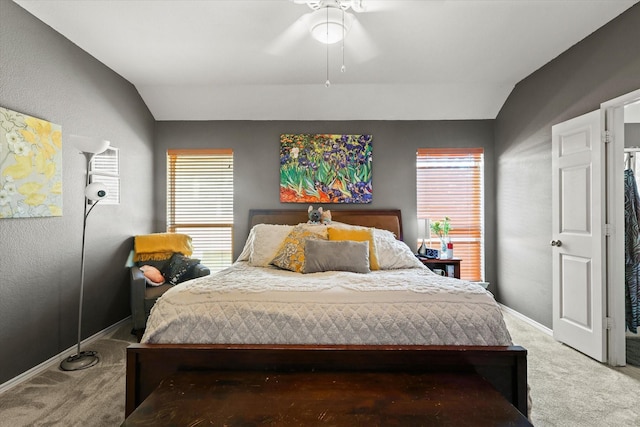 bedroom with ceiling fan, lofted ceiling, and carpet flooring