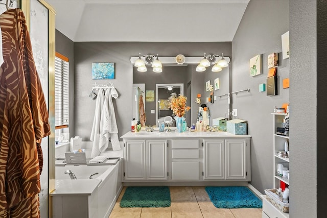 bathroom featuring tile patterned floors, a bath, and vanity